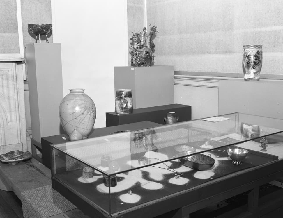 Installation image of California Crafts II in 1961 featuring a display case including works in enamel and metal such as two etched enamel bowls by Dextra Frankel.