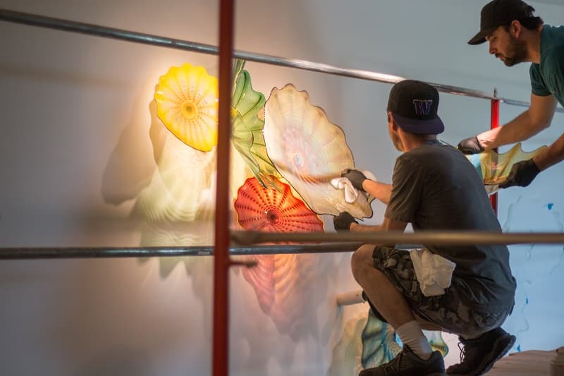 Art handler carefully installing the delicate glass work.
